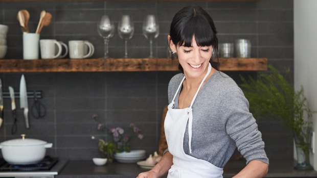 Host Kerry Diamond in a grey kitchen wearing an apron