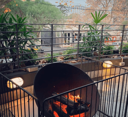 A fenced off fire pit with the Sydney Harbour Bridge in the background