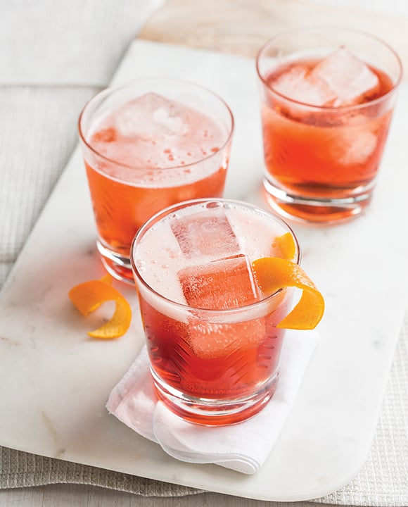 Negroni Sbagliato cocktails topped with orange wheel garnish and ice cubes