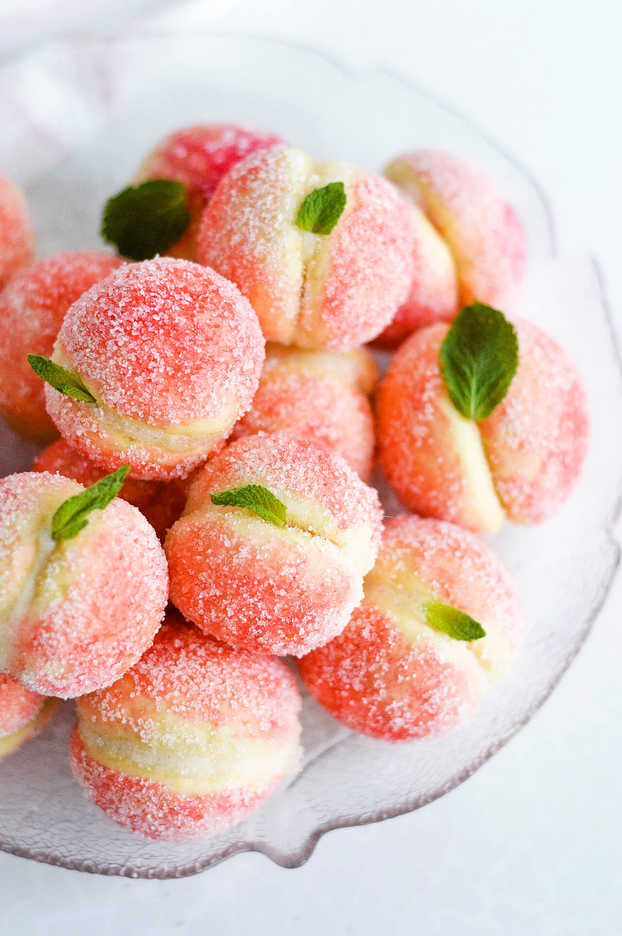 Orange infused sweet ricotta peach cookies with mint leaves and sugar coating